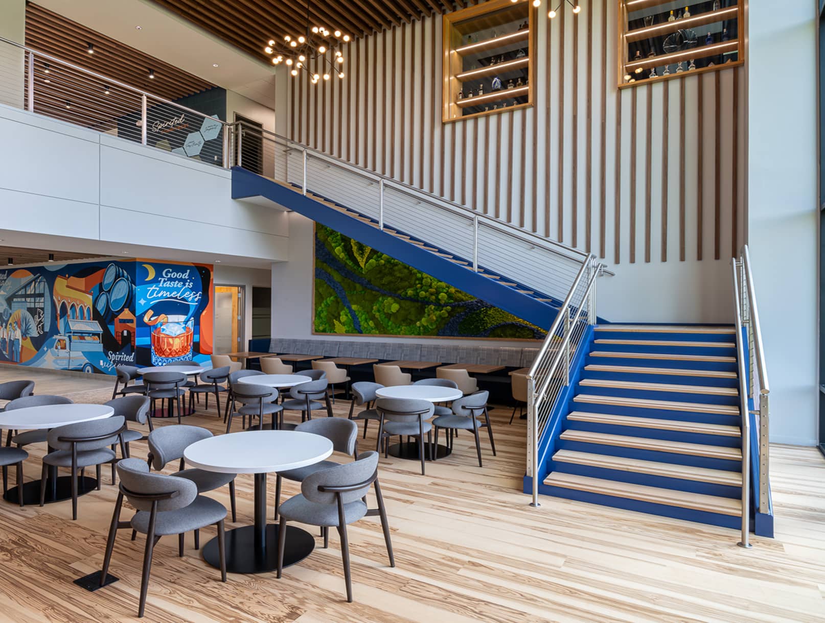 Interior shot of the staircase and atrium with seats and tables.