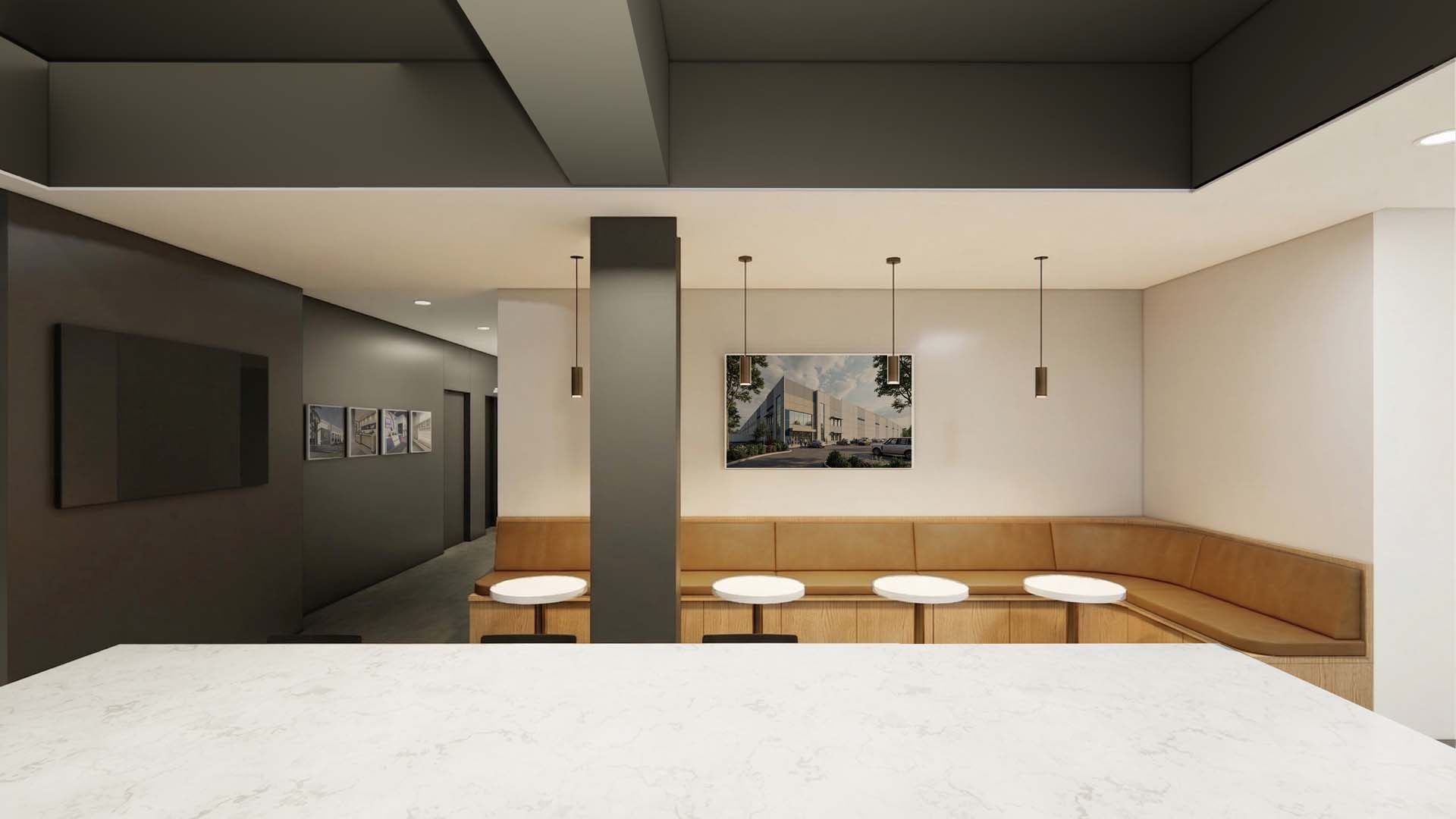 Break room with built-in banquette seating, round tables, and pendant lighting.