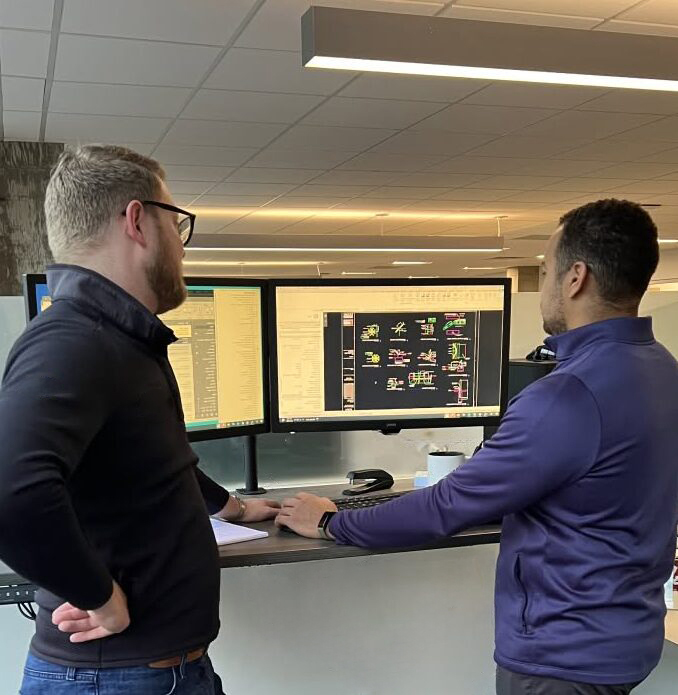 Two team members looking at a computer.