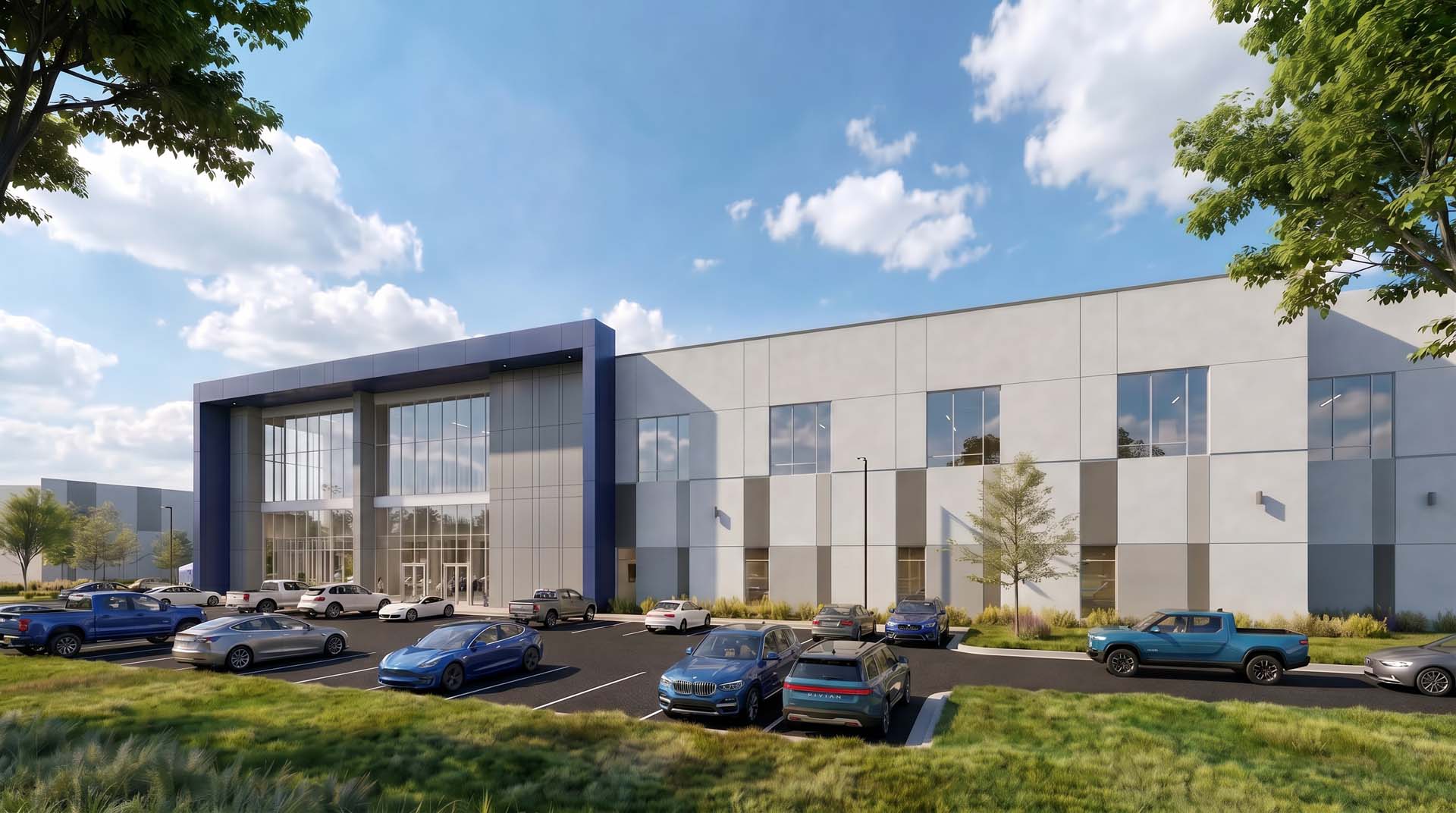 Exterior of two-story industrial building with glass entrance and full parking lot.