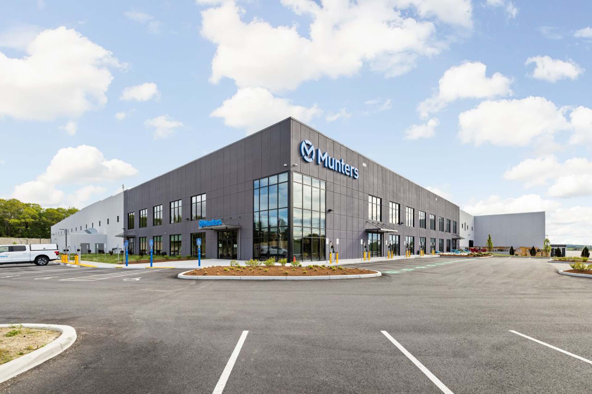 Exterior of Munters office and manufacturing building with glass entrance and parking lot.