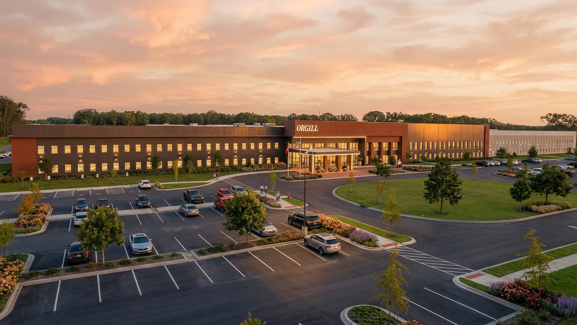 Aerial view of Orgill headquarters building at sunset with parking lot.
