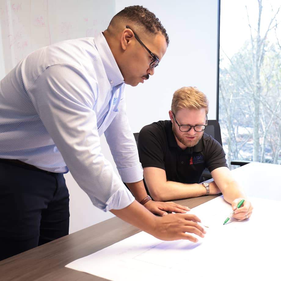 Two team members working on drawings for key services.